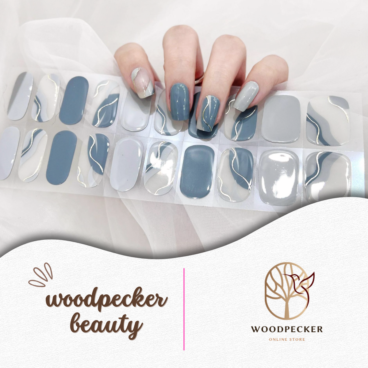 Hand wearing glossy blue-gray and silver wave line gel nail stickers from Woodpecker Beauty
