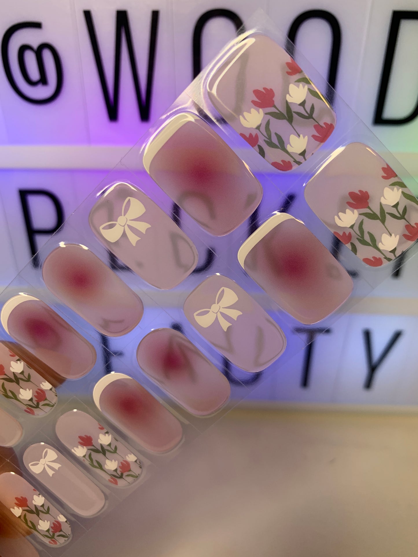 Transparent nail stickers with floral French tip design and subtle shimmer.