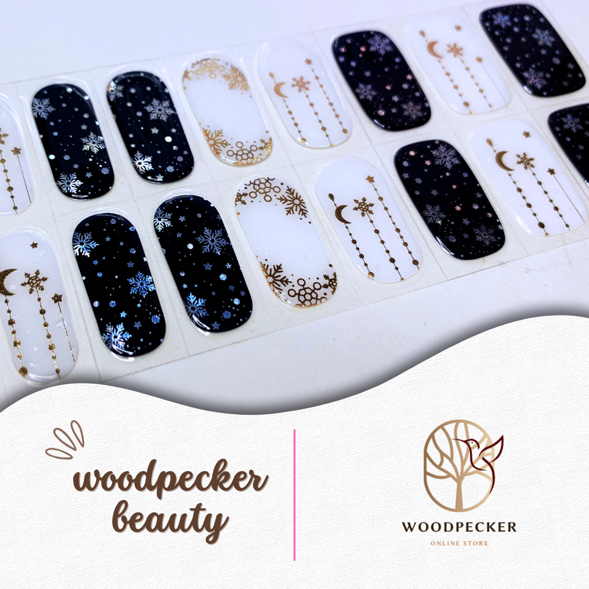 Flat lay of winter-themed nail stickers with navy and nude colors, decorated with snowflakes and gold foil stars.