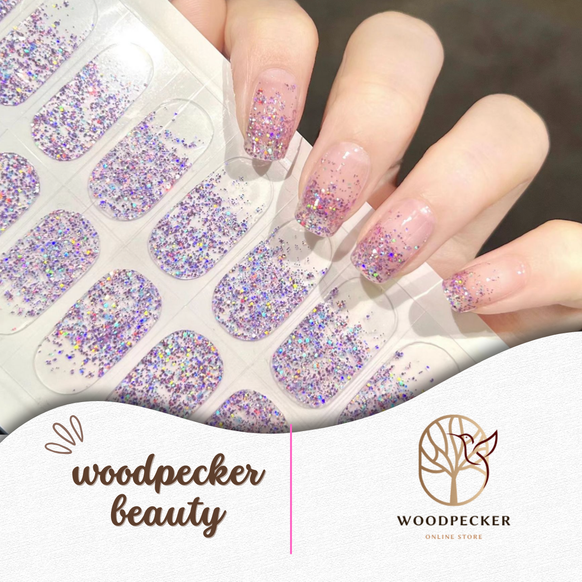 Hand holding a sheet of pink and purple glitter nail wraps, ready to apply