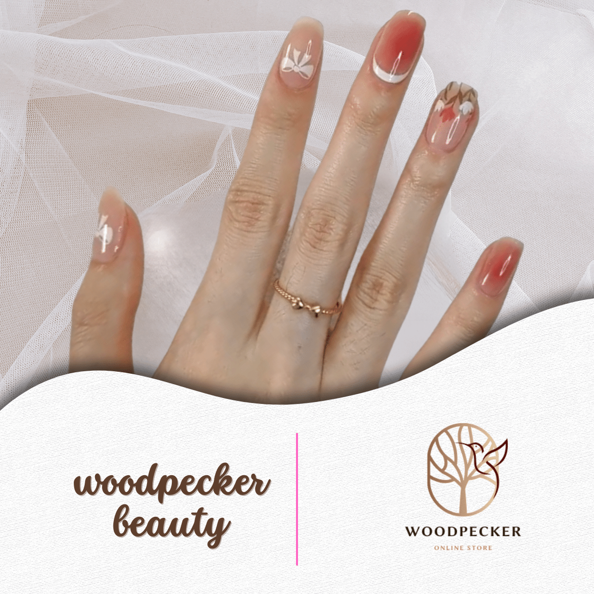 Hand with rosy gradient nail stickers featuring floral and leaf details.