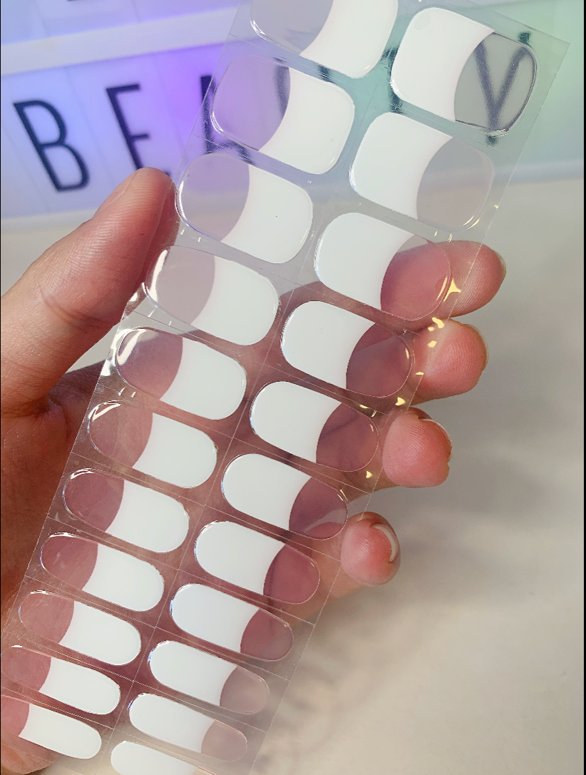 White-tipped French manicure nail wraps displayed on fingers
