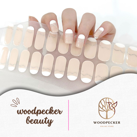 Hand with French nude gel nail stickers featuring white tips and fine gold glitter line – Woodpecker Beauty
