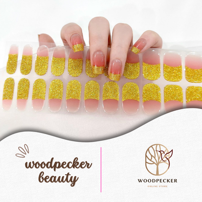  Hand holding full set of gold glitter and nude nail stickers – Woodpecker Beauty