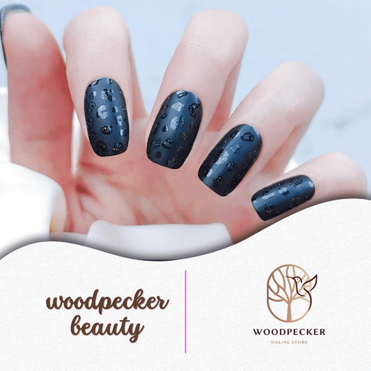 Hand with matte black semi-cured nail stickers featuring subtle leopard texture – Woodpecker Beauty