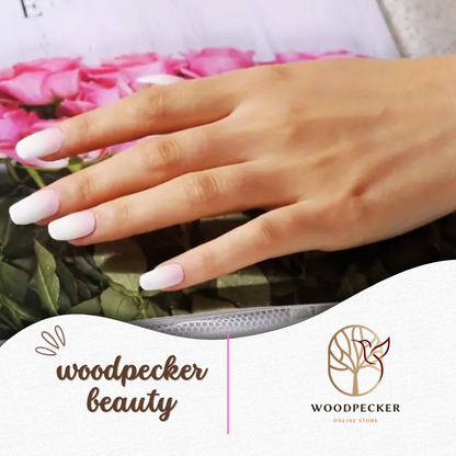 Hand with long French ombre nails placed over pink flowers – Woodpecker Beauty