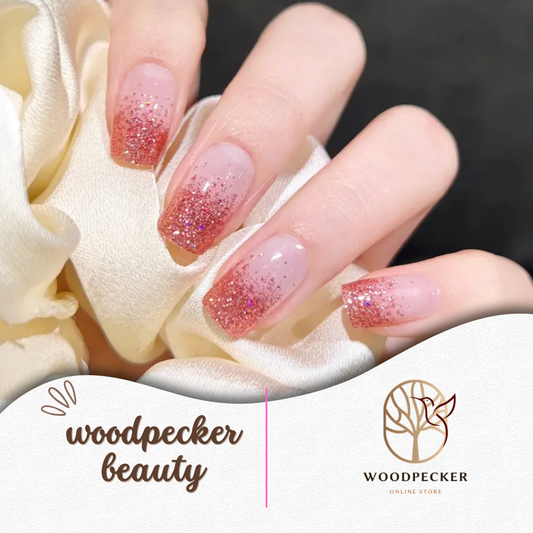 A hand with gradient pink glitter gel nail stickers from Woodpecker Beauty, sparkling from tip to base.
