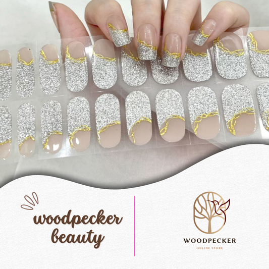 French-style nail stickers with silver glitter and golden wavy edge on a nude base from Woodpecker Beauty
