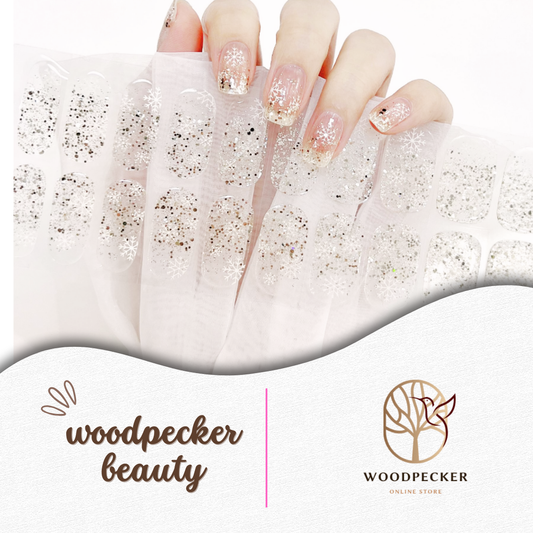 Clear gel nail stickers with silver glitter and white snowflake patterns from Woodpecker Beauty
