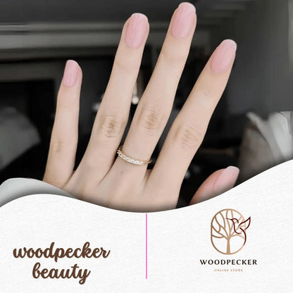 Hand with baby pink nail wraps in natural daylight with gold rings – Woodpecker Beauty