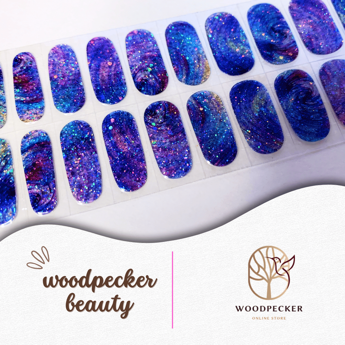Flat lay of vibrant galaxy-themed nail wraps in shades of violet, blue, and hot pink with bold glitter.
