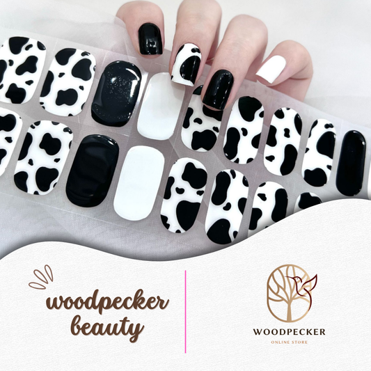 Black and white cow print nail wraps with a mix of solid black and white accents
