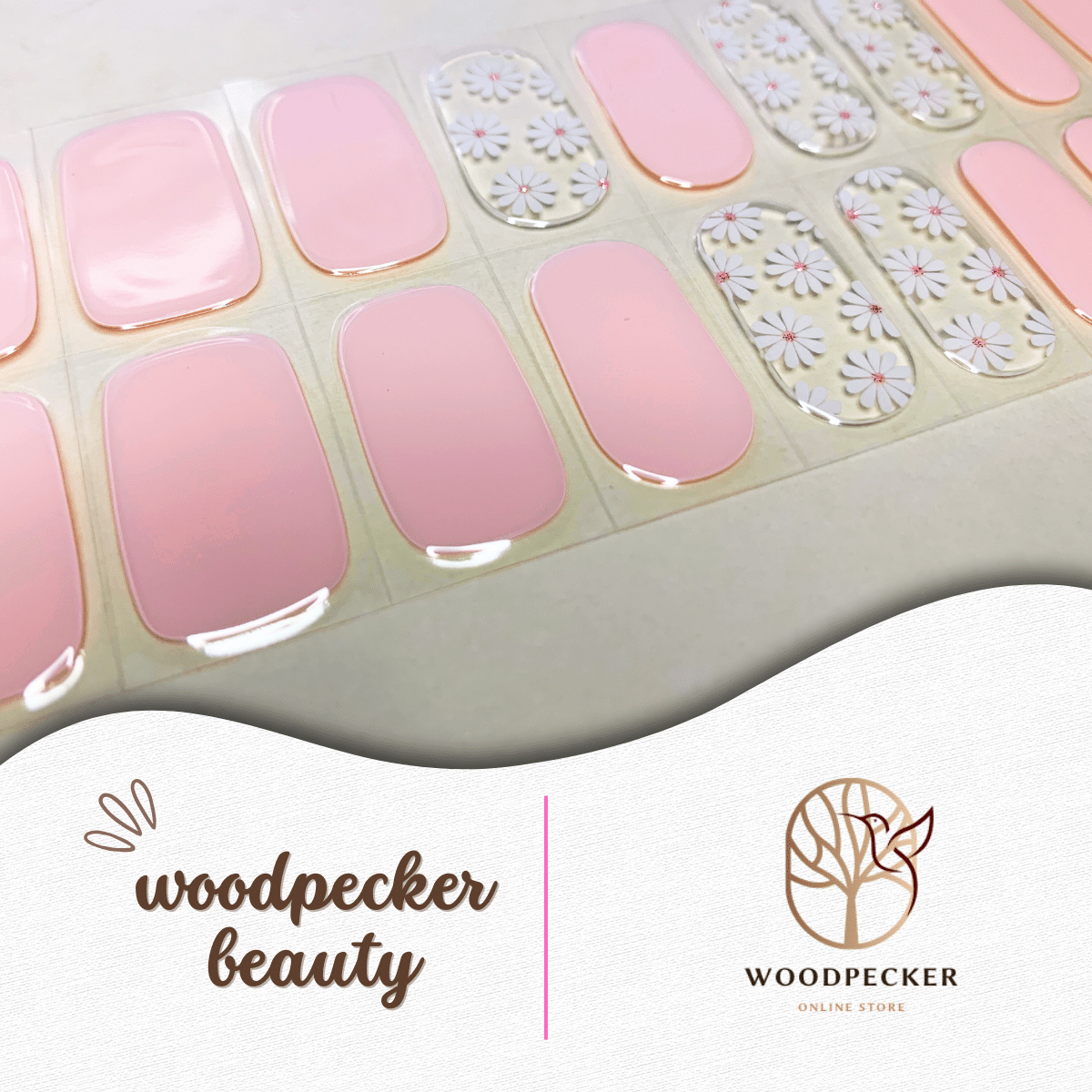 Flat lay of pastel pink and daisy-patterned nail stickers with a glossy finish.
