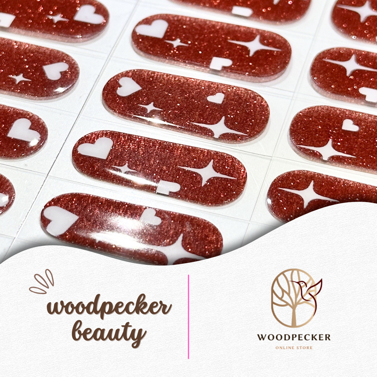 Flat lay of shiny red nail wraps with bold white star prints on each sticker.
