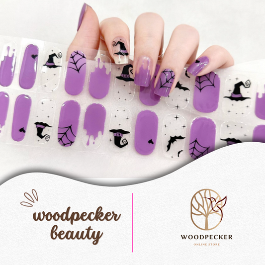 Halloween nail stickers with a pastel purple base, featuring witch hats, spiderwebs, bats, and black drip accents.

