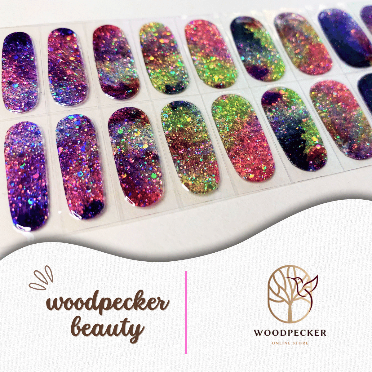 Flat lay of rainbow galaxy nail wraps with chunky glitter and multicolor swirls.
