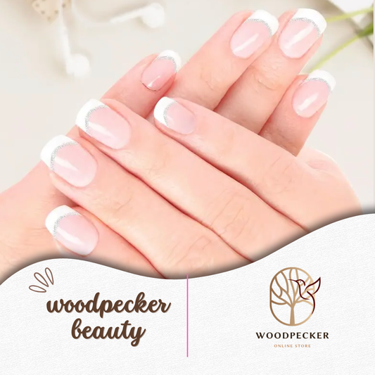 Hand holding pink nail wraps featuring a soft French tip style with metallic silver line detailing.

