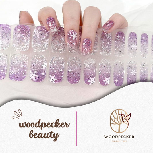 Hand wearing purple glitter snowflake gel nail wraps with matching semi-cured sheet, UV lamp required
